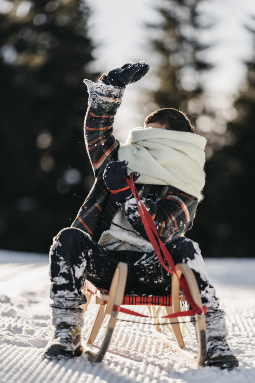 Ein Junge auf einem Schlitten im Salzburger Land