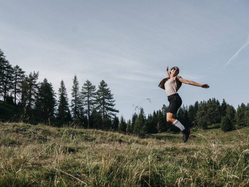 Wanderin hüpft in den Bergen in die Lüfte