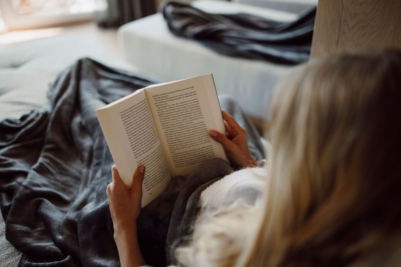 Kind beim Buch lesen und entspannen im Alpina Alpendorf